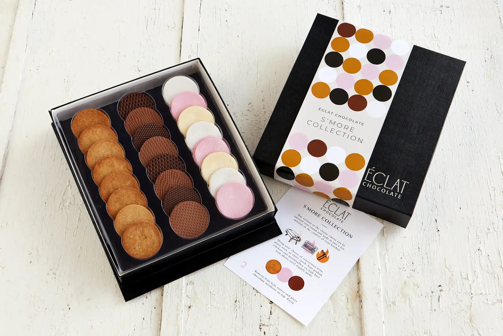 Box of assorted chocolate cookies with a polka dot box on a white surface